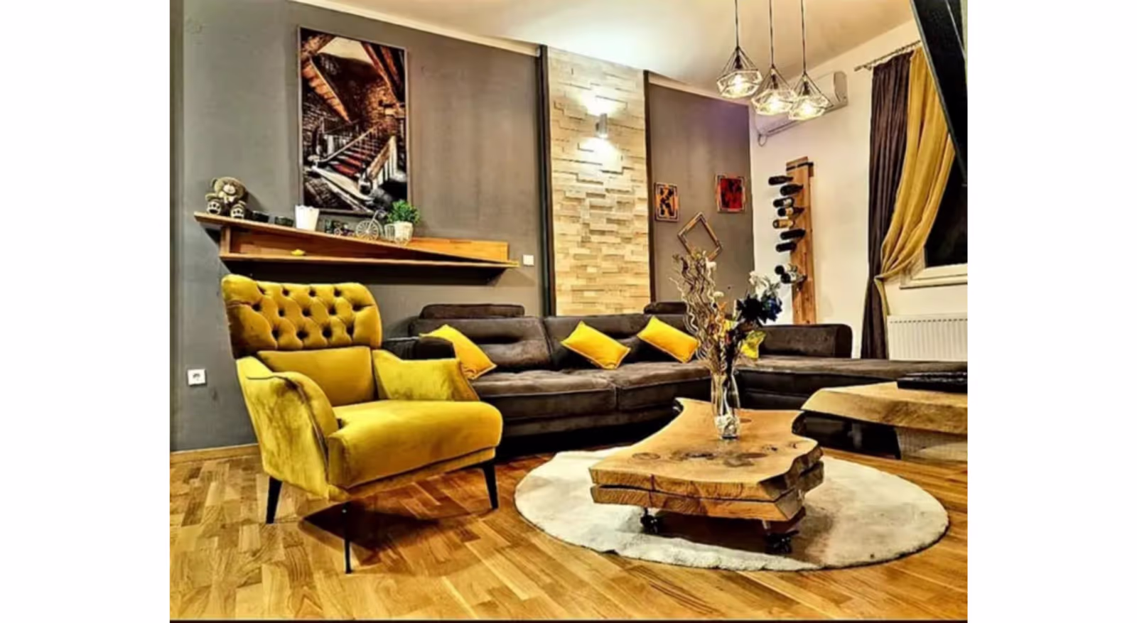 Topla dnevna soba sa žutom foteljom, sivom ugaonom garniturom i drvenim detaljima - apartman Kalina